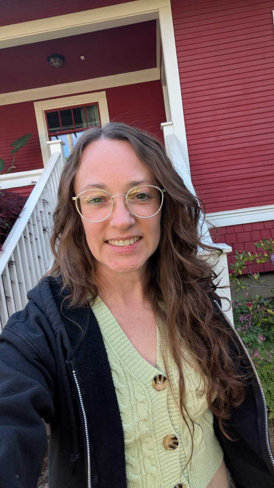 Bonnie, owner of Bon Bon Cleaning Co., standing on their front porch in Southeast Portland